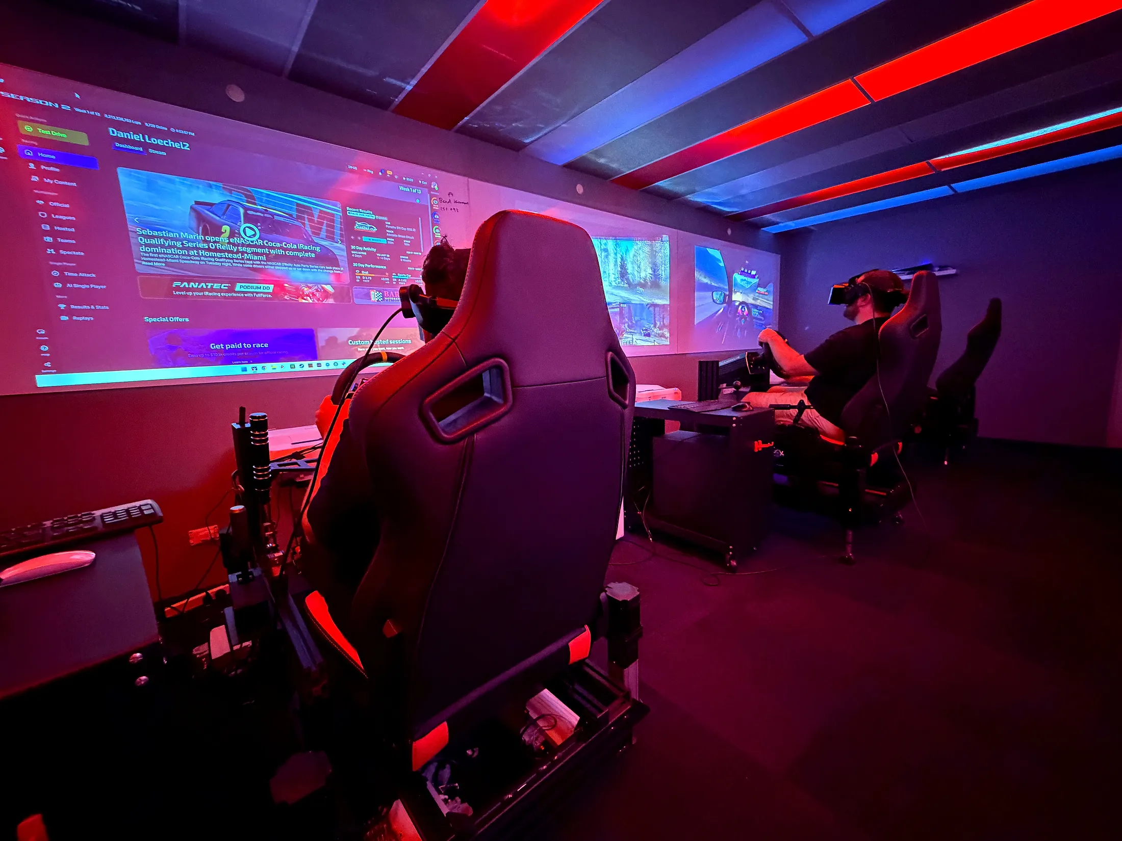 Wide view of the neon race room at Sim Racing Adelaide with VR racers